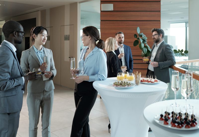 Young intercultural entrepreneurs with champagne discussing best reports Corporate Events